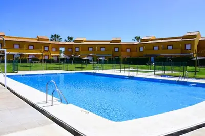 a large swimming pool in front of a building at Charming house in Rota + garden in Rota