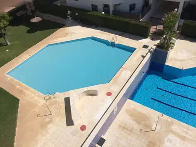 an overhead view of a swimming pool at Luminoso apartamento en playa las redes, entorno natural pinares y dunas. Wifi in El Puerto de Santa María