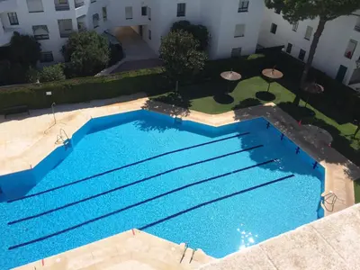 an overhead view of a large blue swimming pool at Luminoso apartamento en playa las redes, entorno natural pinares y dunas. Wifi in El Puerto de Santa María