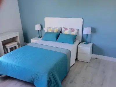 a blue bedroom with a large bed with blue sheets and pillows at Luminoso apartamento en playa las redes, entorno natural pinares y dunas. Wifi in El Puerto de Santa María
