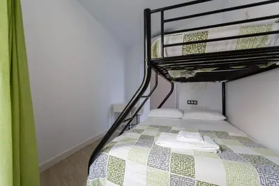 a bedroom with a bunk bed with a bedspread at SAIL Family Home by Cadiz4Rentals in Cádiz