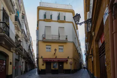 a tall yellow and white building on a street at SAIL Family Home by Cadiz4Rentals in Cádiz