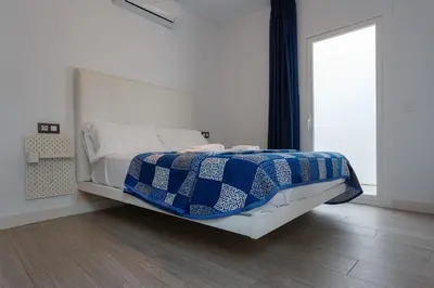 a bedroom with a bed with a blue and white blanket at SAIL Family Home by Cadiz4Rentals in Cádiz