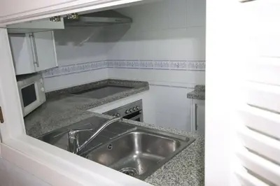 a kitchen with a sink and a stove at Apartamento acogedor en lugar inmejorable in Sanlúcar de Barrameda
