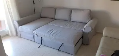 a living room with a white couch and a chair at Apartamento acogedor en lugar inmejorable in Sanlúcar de Barrameda