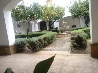 a courtyard with a fountain and trees and bushes at Charming apartment in El Puerto de Santa María with terrace in El Puerto de Santa María