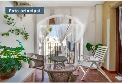 a patio with chairs and a table and a balcony at Charming apartment in El Puerto de Santa María with terrace in El Puerto de Santa María