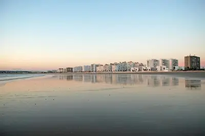 a view of a beach with buildings in the background at Charming apartment in El Puerto de Santa María with terrace in El Puerto de Santa María