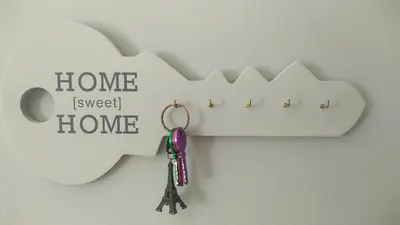 a key chain on a wall with the words home and a house at Sherryflat San Agustín in Jerez de la Frontera