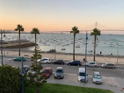 a parking lot with parked cars and boats in the water at Apartamento Aqua Vitae in Cádiz