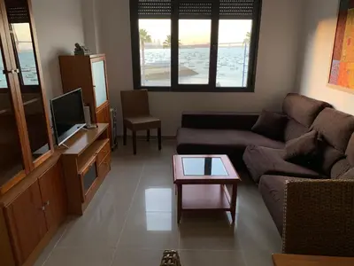 a living room with a couch and a tv and a table at Apartamento Aqua Vitae in Cádiz