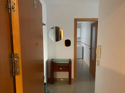 a hallway with a table and a mirror on the wall at Apartamento Aqua Vitae in Cádiz