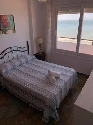 a teddy bear sitting on a bed in a bedroom at El Mirador de la Playa Cortadura Grupo AC Gestion in Cádiz