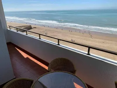 a balcony with a view of a beach and the ocean at El Mirador de la Playa Cortadura Grupo AC Gestion in Cádiz