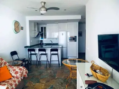 a living room with a kitchen with a table and chairs at El Mirador de la Playa Cortadura Grupo AC Gestion in Cádiz