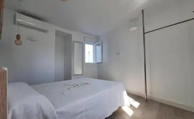 a white bedroom with a bed and a window at TU DENSCANSO EN VALDELAGRANA FRENTE AL MAR in El Puerto de Santa María