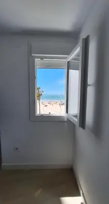 a window in a room with a view of a beach at TU DENSCANSO EN VALDELAGRANA FRENTE AL MAR in El Puerto de Santa María