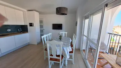 a kitchen and dining room with a table and chairs at TU DENSCANSO EN VALDELAGRANA FRENTE AL MAR in El Puerto de Santa María
