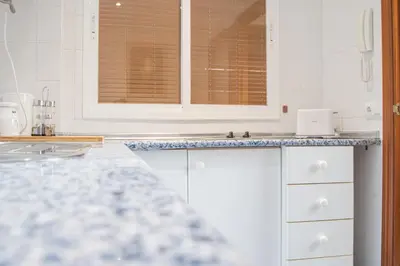 a kitchen with white cabinets and a counter top at Apartment Cadiz´s Angel in Cádiz