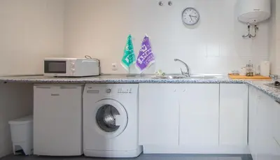 a kitchen with a washing machine and a microwave at Apartment Cadiz´s Angel in Cádiz