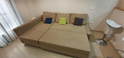a brown couch with four pillows in a living room at Los luceros in Rota