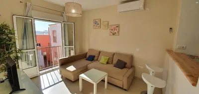 a living room with a couch and a balcony at Los luceros in Rota