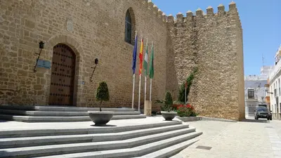 a building with three flags in front of it at Los luceros in Rota