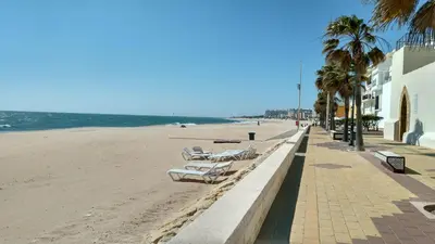a row of lounge chairs on the beach at Los luceros in Rota