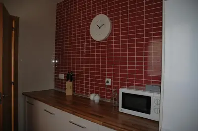 a kitchen with a microwave and a red tiled wall at Apartamento Costa Ballena in Chipiona