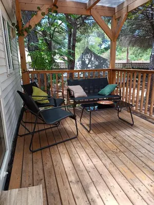 two chairs and a table on a deck at The PineForest Cabin in Chiclana de la Frontera