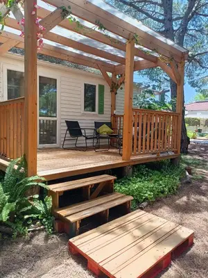 a wooden deck with a picnic table and benches at The PineForest Cabin in Chiclana de la Frontera