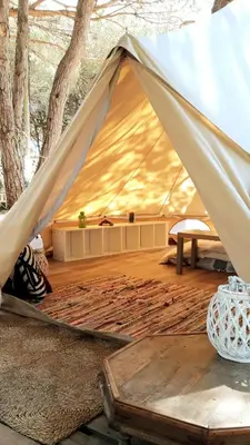 a tent with a wooden floor and a table at The PineForest Cabin in Chiclana de la Frontera