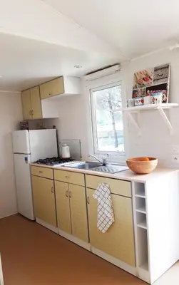 a kitchen with yellow cabinets and a white refrigerator at The PineForest Cabin in Chiclana de la Frontera