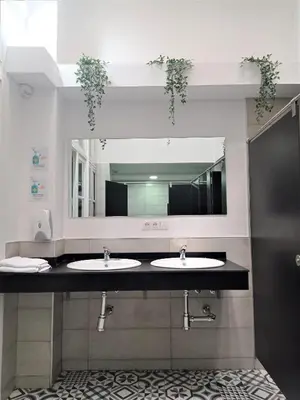 a bathroom with two sinks and a large mirror at Planeta Cadiz Hostel in Cádiz