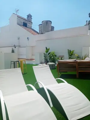 a group of white chairs sitting on a roof at Planeta Cadiz Hostel in Cádiz