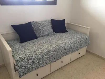 a bed with two blue pillows on top of it at PISO 1ª LINEA SANLUCAR DE BARRAMEDA in Sanlúcar de Barrameda