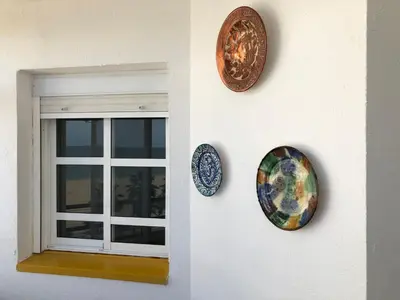 three plates on a wall next to a window at PISO 1ª LINEA SANLUCAR DE BARRAMEDA in Sanlúcar de Barrameda