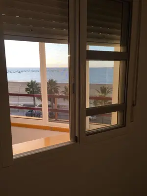 a room with a window looking out at the beach at PISO 1ª LINEA SANLUCAR DE BARRAMEDA in Sanlúcar de Barrameda