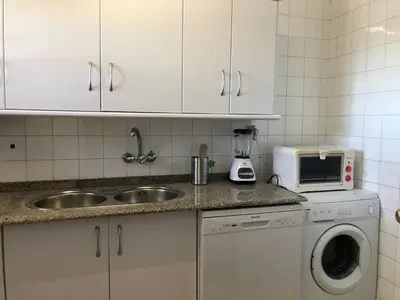 a kitchen with white cabinets and a sink and a microwave at PISO 1ª LINEA SANLUCAR DE BARRAMEDA in Sanlúcar de Barrameda