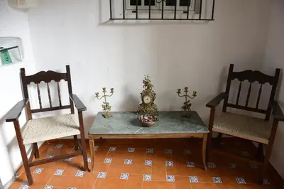 a room with two chairs and a table with a vase at Casa Rural Las Cadenas del Cananeo in Arcos de la Frontera