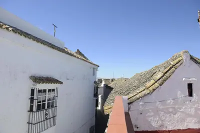 an alley between two white buildings with a roof at Casa Rural Las Cadenas del Cananeo in Arcos de la Frontera
