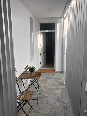 a hallway with a table and two chairs and a door at Apartamento Gran Teatro Falla-La Caleta in Cádiz