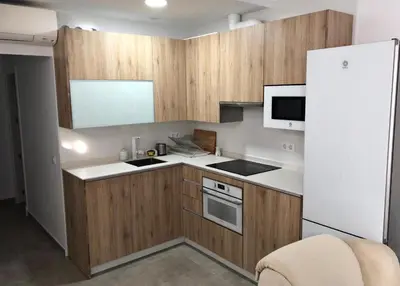 a kitchen with wooden cabinets and a stove top oven at Apartamento Gran Teatro Falla-La Caleta in Cádiz