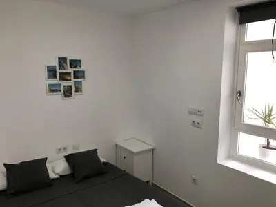 a white room with a bed and a window at Apartamento Gran Teatro Falla-La Caleta in Cádiz