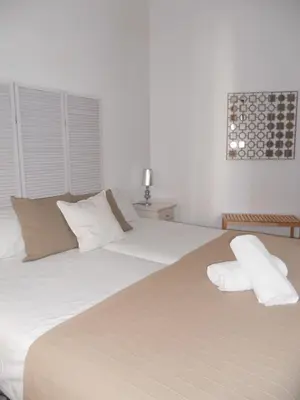 a large white bed with two pillows on it at Santa María 12 Boutique Apartamentos in Cádiz