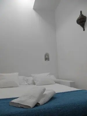 a white bed with two pillows on top of it at Santa María 12 Boutique Apartamentos in Cádiz