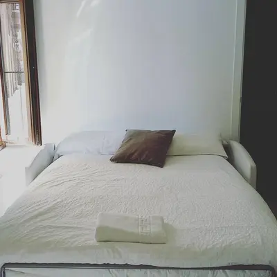 a white bed with a pillow on top of it at Santa María 12 Boutique Apartamentos in Cádiz
