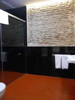 a bathroom with a sink and a brick wall at Santa María 12 Boutique Apartamentos in Cádiz