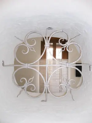 a metal chandelier hanging on a wall with a window at Santa María 12 Boutique Apartamentos in Cádiz