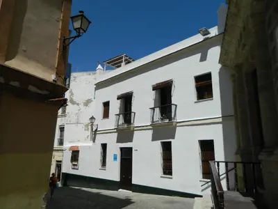 a white building with windows on a street at Santa María 12 Boutique Apartamentos in Cádiz